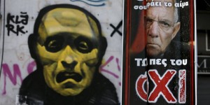 A referendum campaign poster depicting German Finance Minister Schaeuble is seen before a political graffiti in Athens